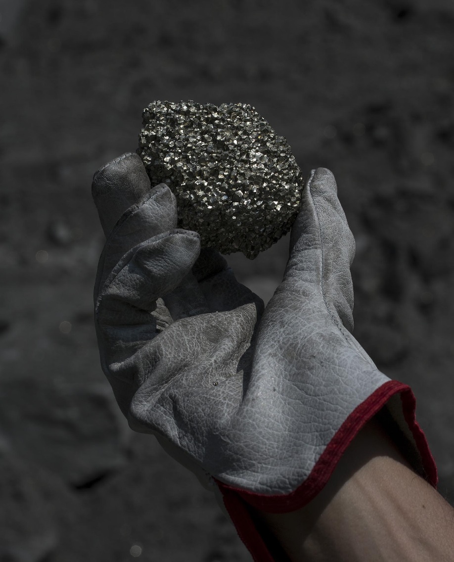 Photo: Hand with glove holding ore